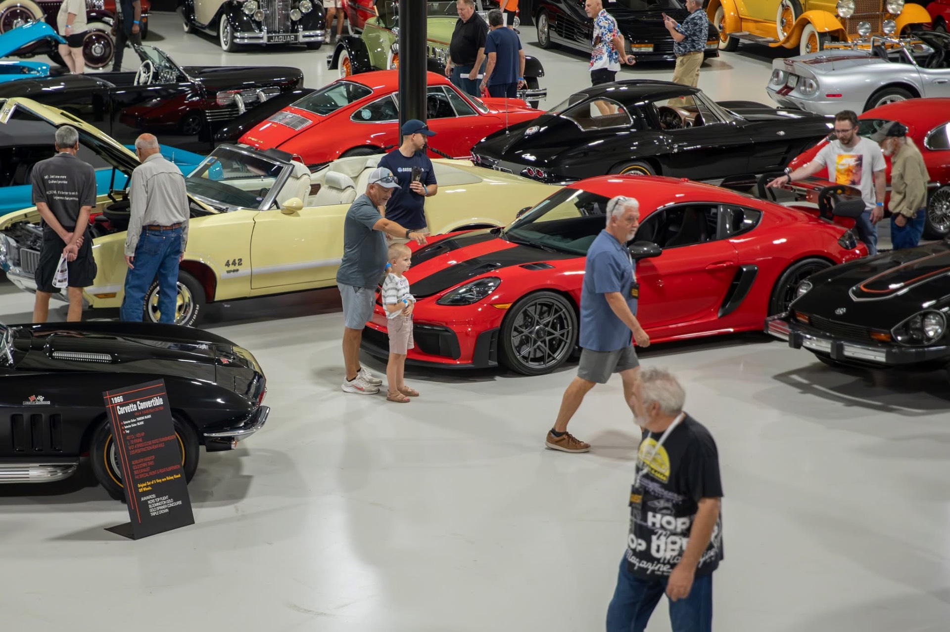 Visitors admiring classic and sports cars in the showroom
